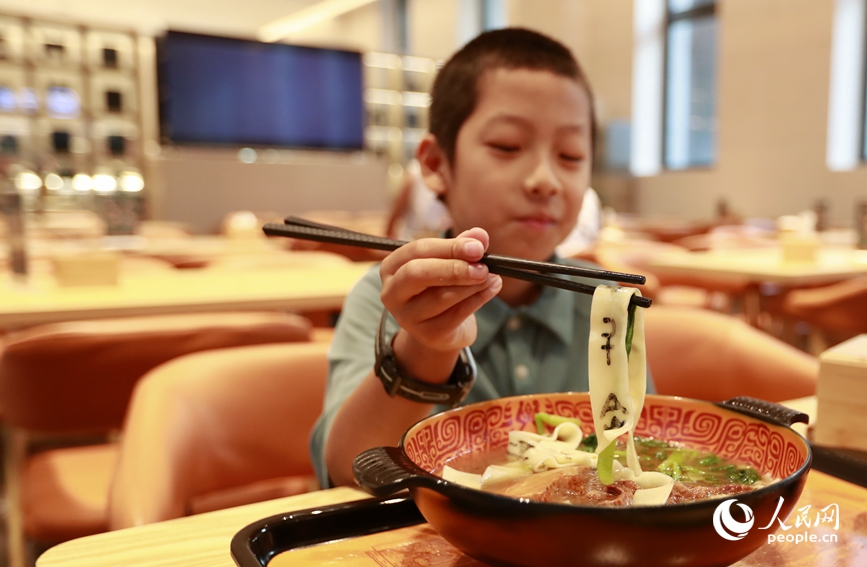 殷墟博物館推出的甲骨文面深受游客喜愛。人民網(wǎng)記者 慎志遠(yuǎn) 攝